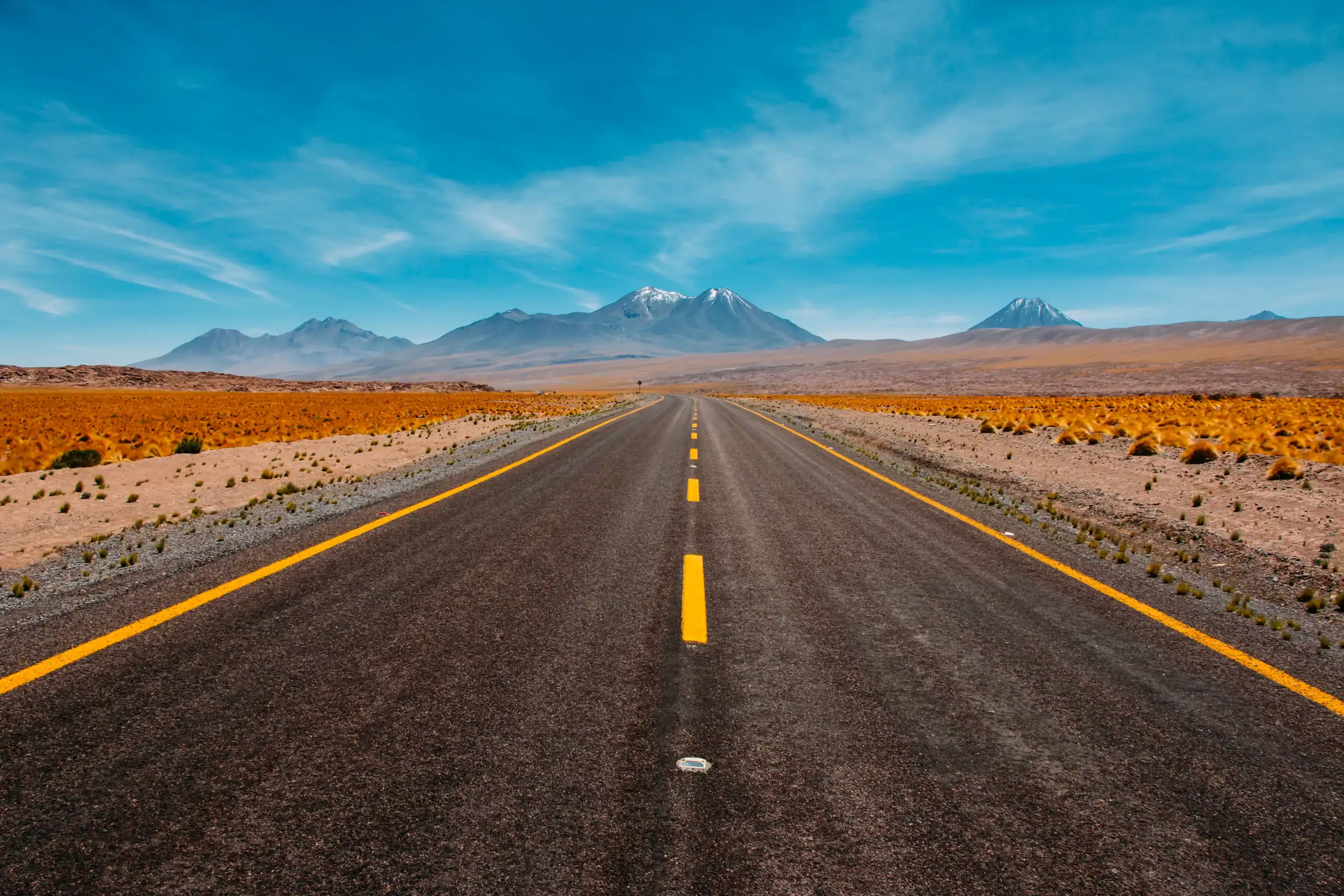 An open desert road underneath a blue sky