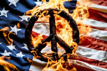 Burning peace sign on an American flag